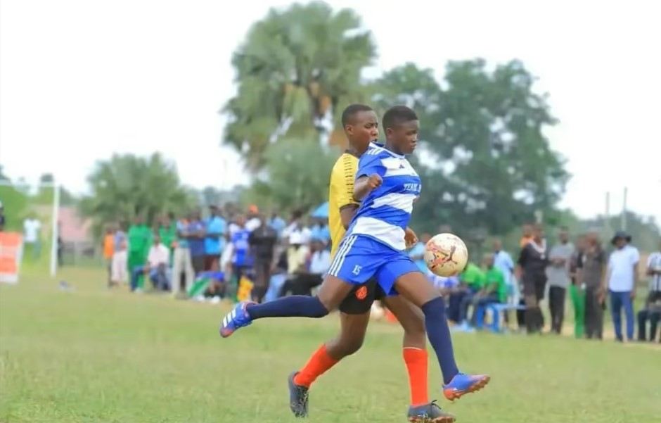 A Boni Consilii footballer in blue and white stripes controls the ball during a match