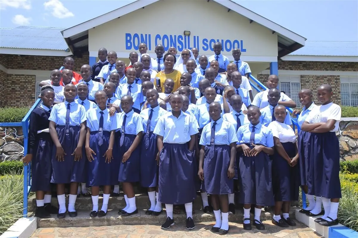 O level students in light-blue blouses and navy skirts on the steps of the school building