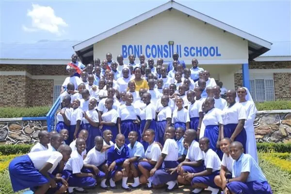 Students and a sister gathered on the steps in front of the Boni Consilii School building